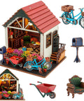 Totally Awesome Miniature Dollhouse Kit With 3D Wooden Tiny Building Model Puzzle And LED Lights For Beginners featuring a detailed garden and house model with intricate wooden pieces and vibrant flowers.