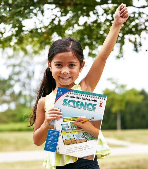 Child holding Interactive Notebooks For First Grade Kid Friendly Reproducible Workbook Covering Physical Space And Earth Science