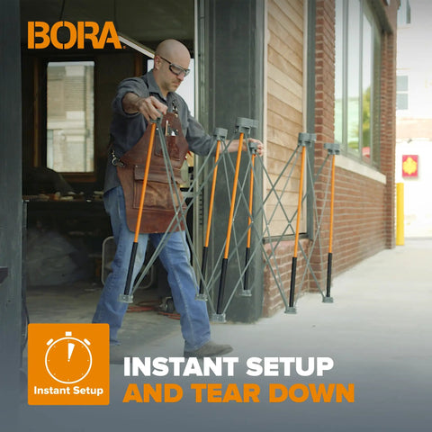 Man carrying unfolded Beefy Folding Work Table Centipede Saw Horse Stand 2 ft long by 4 ft wide by 2.5 ft high steel 1500 lb capacity