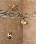 Bathroom corner with Wynford Corner Shower Basket In Brushed Nickel For Bathroom Storage, holding soap and sponge.