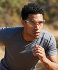 Man in athletic gear wearing Straight Up Durable Four Pack Kickass Wraparound Safety Glasses featuring soft silicone frames.