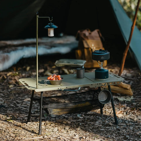 Grab And Go Tactical Camping Table With Adjustable Height, collapsible lightweight folding table set up in a forest environment.