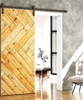 Wooden sliding door with chevron pattern in modern room, highlighting door track hardware and natural light reflection.