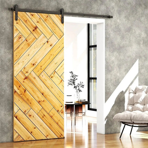 Wooden sliding door with chevron pattern in modern room, highlighting door track hardware and natural light reflection.