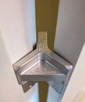 Patented Safety Bar Door Stop for Tension Hinged Doors in metal installed on a door, holds door secure at 90-degree angle without damage.