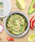 18/8 Stainless Steel Mortar And Pestle Set with guacamole, surrounded by avocado, lime, and chili peppers on wooden surface