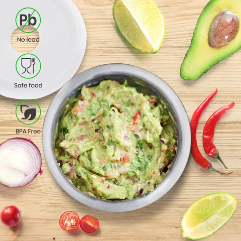 18/8 Stainless Steel Mortar And Pestle Set with guacamole, surrounded by avocado, lime, and chili peppers on wooden surface