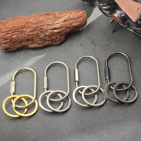 Solid Brass Carabiner Keychain Clip With Screw Lock Built To Last Rugged Key Organizer on concrete next to wood