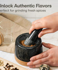 Hands using Heavy Duty 1 Cup Granite Mortar And Pestle Set For Spices And Herbs Molcajete Style Stone Grinder With Non Slip Wooden Base.