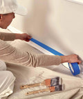 Person laying tape over Heavy Duty Cotton Canvas Drop Cloth Set, 4 X 12 Feet, Pack Of 2, Painters Drop Cloth on floor.