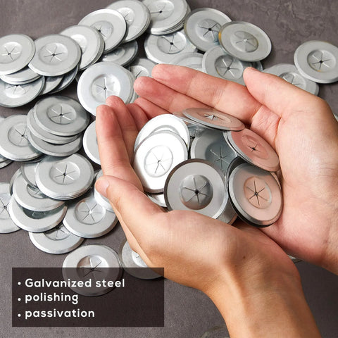 Front view: 1.5-inch galvanized steel plaster washers, round flat discs held in hands with many more on the surface.