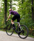 Cyclist riding with Two Pack Heavy Duty Bike Tubes With AV32mm Schrader Valve for 27x1 1/4 and 27x1 3/8 tires in forest.