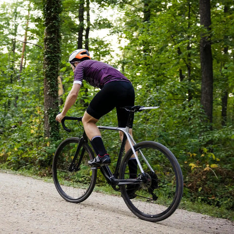 Cyclist riding with Two Pack Heavy Duty Bike Tubes With AV32mm Schrader Valve for 27x1 1/4 and 27x1 3/8 tires in forest.