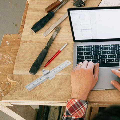 Stainless Steel Ruler With Clip Stopper on a wooden desk beside a laptop, Precision Machinist Straight Edge visible.
