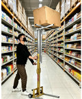 Heavy Duty Portable Fork Lift Manual Stacker With Winch Handles Up To 80kg lifting a box in a store aisle.