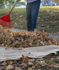 Person raking leaves onto Heavy Duty Burlap Garden Fabric 12 Oz Odorless Food Grade For Weed Blocking And Erosion Control
