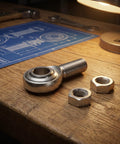 3/4 Inch Steel Heim Joint Rod End With Two Nuts And Right Hand Thread For Quick Installation on wooden table with blueprint