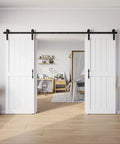 Rock Solid Double Sliding Barn Door 30 By 84 Inches White Primed Mdf And Pvc with 10 foot hardware in a modern room.