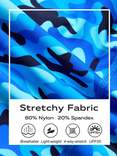 Close-up of youth boys swim jammers fabric showing blue wave pattern, nylon-spandex blend, detailed for competitive team use, size small.
