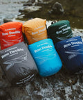 Colorful packs of Roo Double Hammock With GravitasX Water Resistant Breathable Ripstop Fabric on rocky outdoor setting