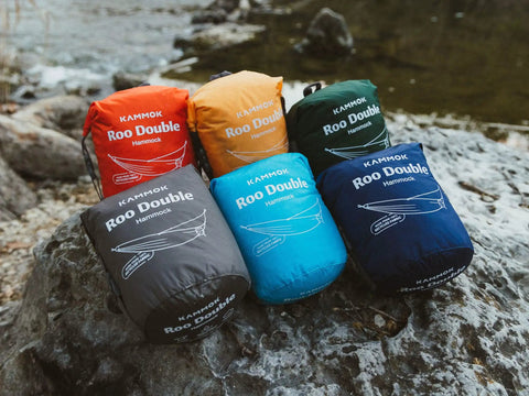 Colorful packs of Roo Double Hammock With GravitasX Water Resistant Breathable Ripstop Fabric on rocky outdoor setting