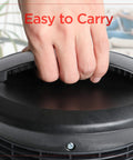 Close-up of a hand holding the handle of a 360 Degree Surround Desk Heater And Fan For Office And Home Use.