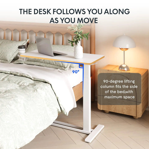 32 Inch Mobile Standing Desk Featuring A Slick Rolling Base And Hassle Free Pneumatic Height Adjustments With Smooth One Hand Gas Spring Lift For Compact Home Office Computer Workstation Setup beside a bed with laptop.