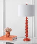 Jenna Orange Stacked Ball Table Lamp with white shade on a desk in living room, bedroom, or home office.