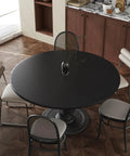 Round wooden dining table with chairs in modern kitchen setting, highlighting 24 Inch By 196 Inch Black Wood Peel And Stick Wallpaper.