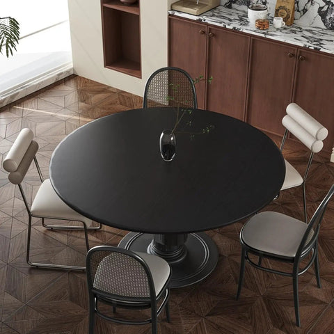 Round wooden dining table with chairs in modern kitchen setting, highlighting 24 Inch By 196 Inch Black Wood Peel And Stick Wallpaper.
