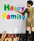 Woman arranging Go To Alphabet Letters Kit For Home And Classroom 288 Piece Bulletin Board Set with colorful letters on wall