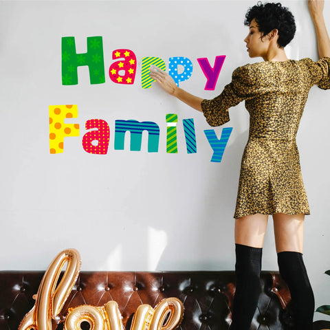 Woman arranging Go To Alphabet Letters Kit For Home And Classroom 288 Piece Bulletin Board Set with colorful letters on wall