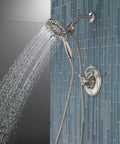4-Setting In2ition 2-In-1 Dual Shower Head With Handheld Spray, Brushed Nickel Detachable Head With Hose, 1.75 GPM Flow, mounted on blue tiled wall.