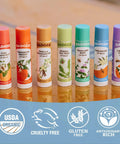 Must Have Organic Lip Balm Gift Set Four Flavor Pack Featuring Tangerine Lavender Orange Vanilla Grapefruit tubes on table