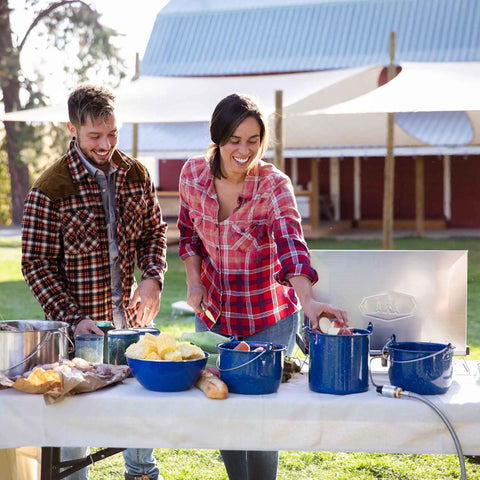 Couple using 1.75 Quart Enamel Camp Pot With Lid And Bail Handle For Outdoor Cooking Camping And Travel, blue speckle finish