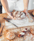 Baker holding bread with Double Acting Baking Powder In A Resealable Bucket For Cookies Cakes Muffins Biscuits And Pancakes.