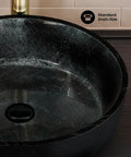 Close-up of Avallon 16.5 Inch Round Glass Vessel Sink in black, showcasing the smooth tempered glass and standard 1.75 inch drain opening.