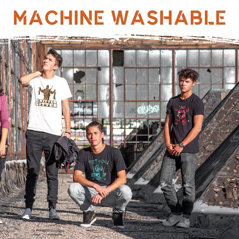 Four people wearing graphic T-shirts in an outdoor setting, showcasing machine washable designs.