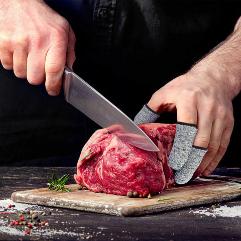 Man using 20 Piece Cut Resistant Finger Cots And Finger Sleeves Reusable Thumb Protectors for safe meat cutting with knife.