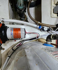 12V RV Water Pump 5.5 GPM 60 PSI Heavy Duty Diaphragm Pump installed with pipes and electrical connections in a boat.