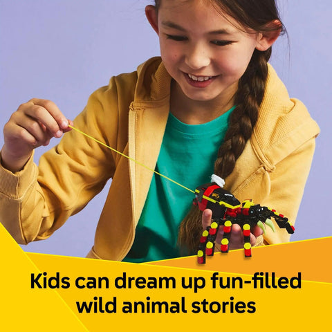 Girl enjoying the Awesome Building Kit Featuring Rad Spider Scorpion And Snake Models, holding a colorful spider model.