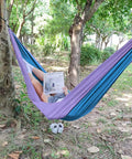 Person relaxing in a 400 Lb Capacity Portable Camping Hammock With Quick Setup Under 3 Minutes, Heavy Duty 210D Nylon Taffeta, 103 Inch Long By 55 Inch Wide