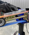 Level Up Your Garage Operation With This Hardcore One Horsepower Belt Sander And Bench Grinder Combo showing grinding action on a metal piece.