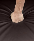 Close-up of a hand pressing into cushy brown PU leather on Comfy Padded Seat Recliner Chairs Set Of 2 For Home Theater