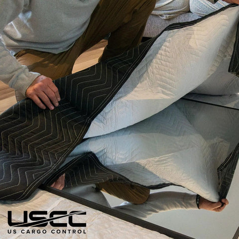 Person holding Heavy Duty Moving Blankets 72x80 Inches 4 Pack Black Padded Furniture Pads showcasing quilted cotton-polyester material.