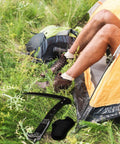 Camping scene with Folding Sickle Garden Tool With Wooden Handle And Sheath Portable Sharp Grass Cutter next to tent on grass.