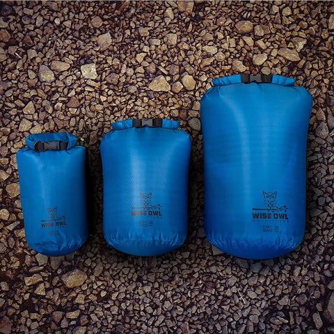 Three Pack Waterproof Dry Bags Set 5L 10L 20L Blue Ripstop Nylon on rocky ground