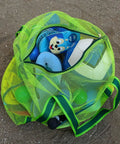 Green Must-Have Mesh Beach Toy Bag With Zipper Top, full of toys, on sandy ground, ideal for quick dry and easy carry. 