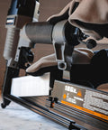 Close-up of 3 In 1 Pneumatic Nail Gun That Rocks A 16 GA Finish Nailer 18 GA Brad Nailer And Stapler in use on a workshop table.