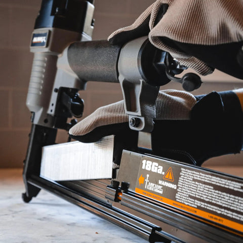 Close-up of 3 In 1 Pneumatic Nail Gun That Rocks A 16 GA Finish Nailer 18 GA Brad Nailer And Stapler in use on a workshop table.